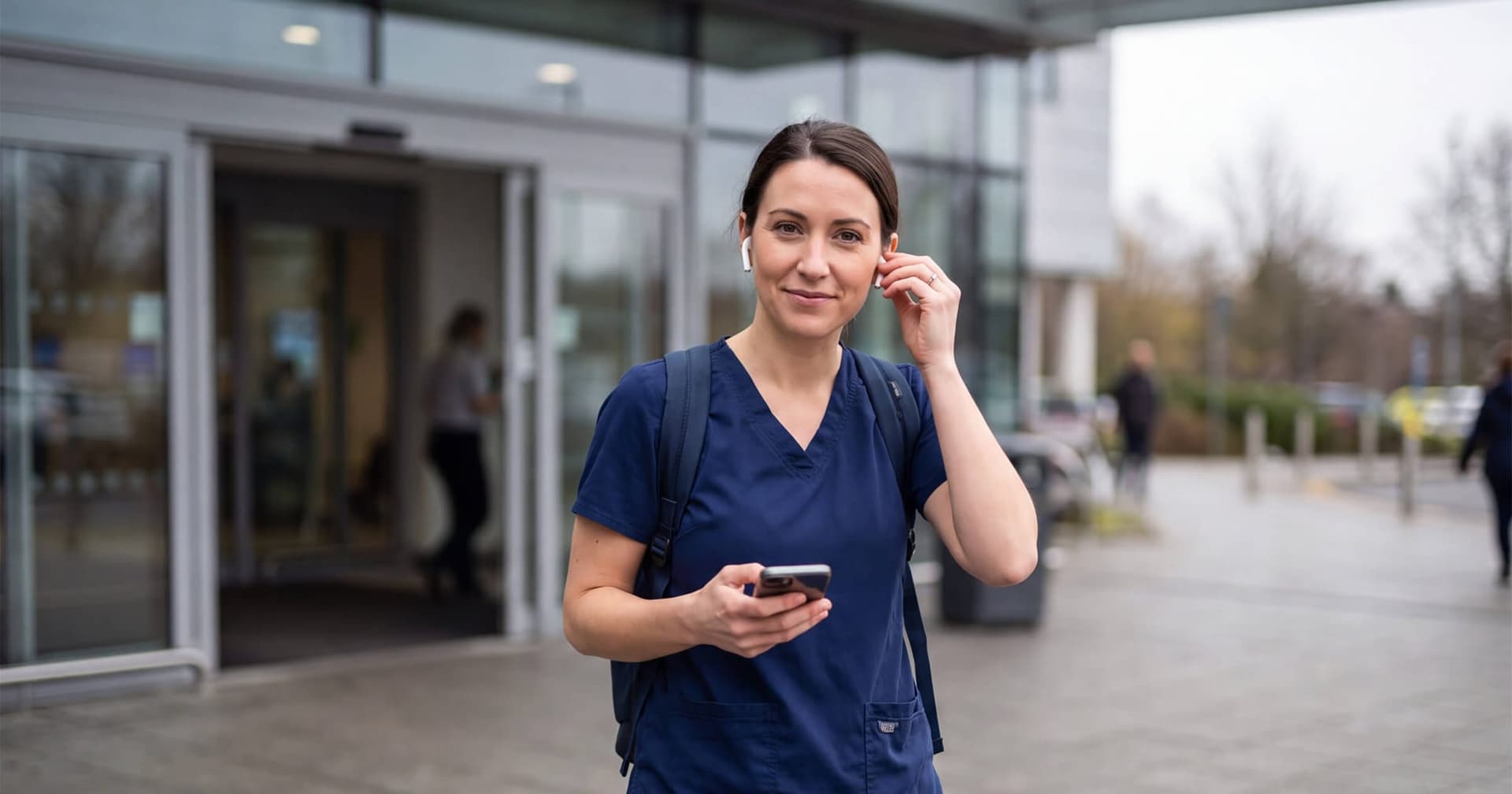 A healthcare professional leaving a hospital and listening to health podcasts
